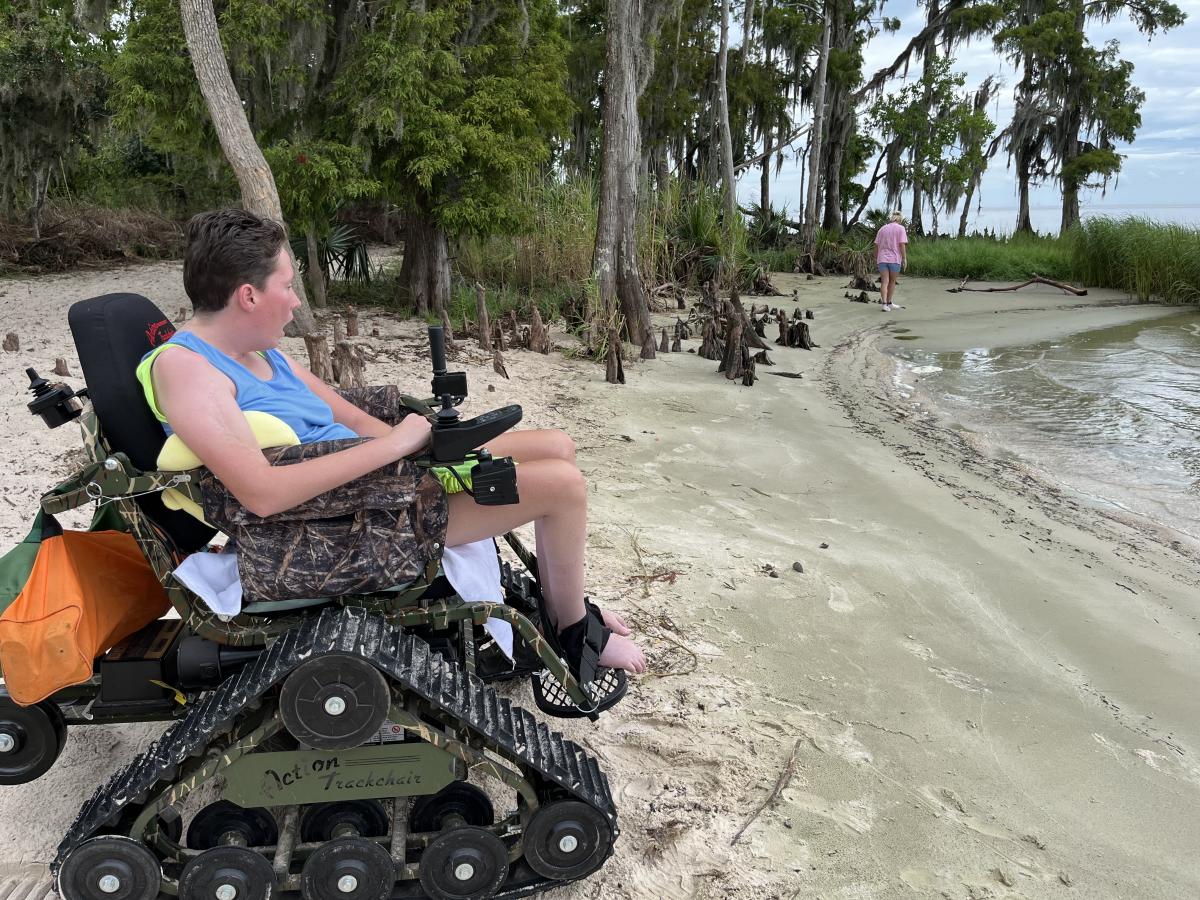 PJ using an all-terrain track wheelchair on the beach inside Fontainebleau State Park.