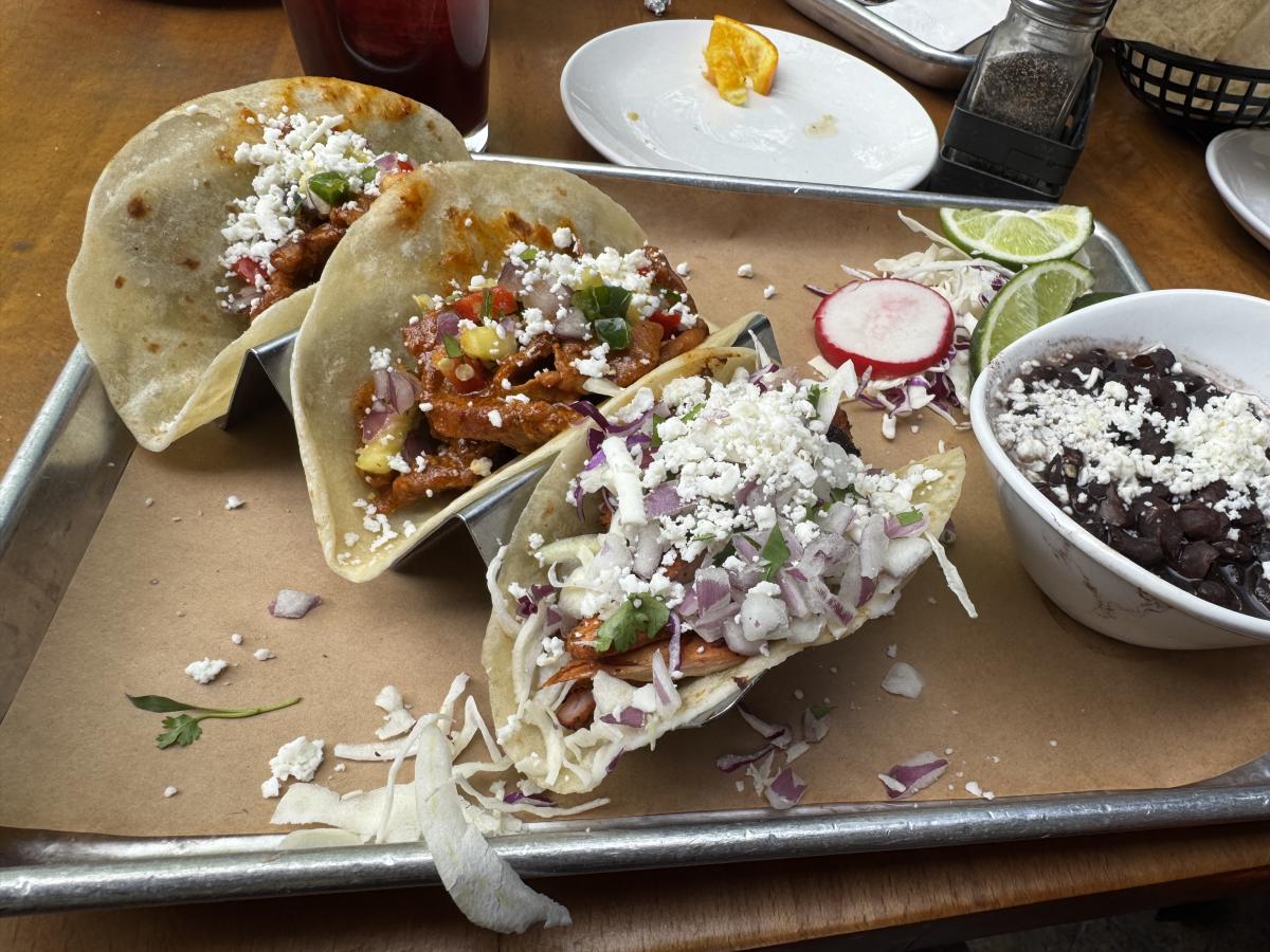 A photo of a dish with three tacos