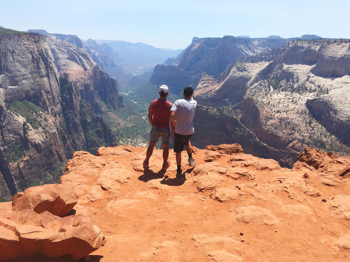 Two men standing at the edge of Angels Landing looking over Zion National Park