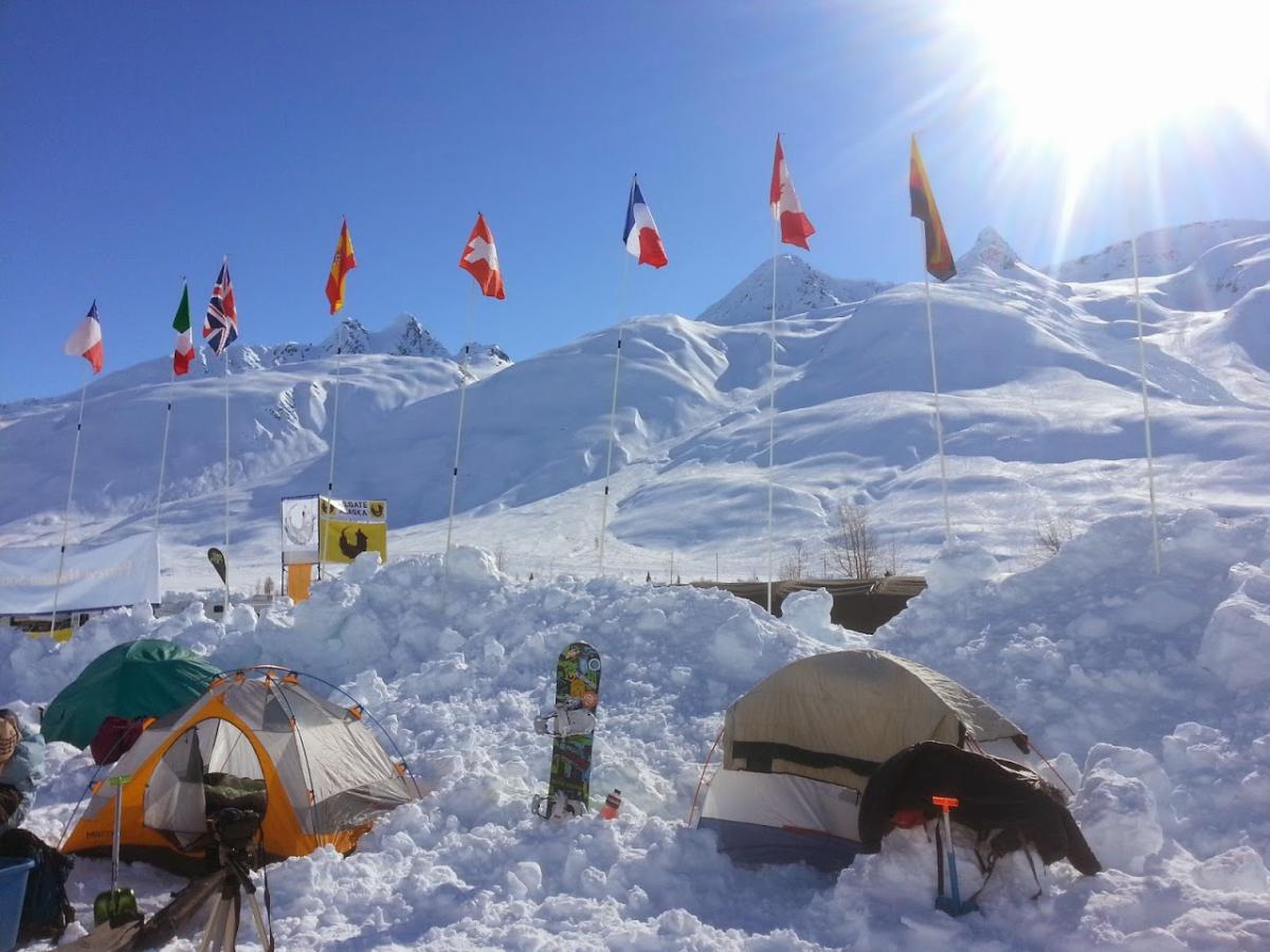 Flags, snowboards, and tents in a winter camp