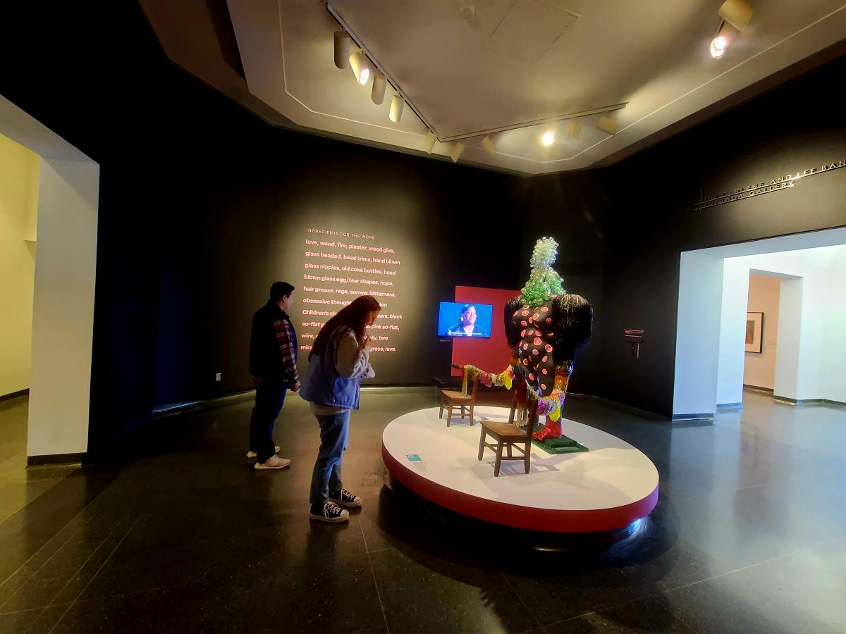 Two poeple look at artwork on display at the Wichita Art Museum