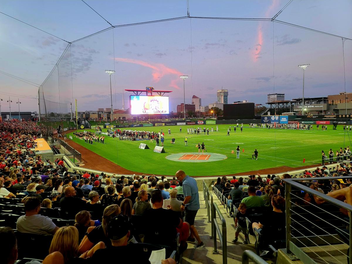 Riverfront Stadium is photographed at dusk during a game with players on the field