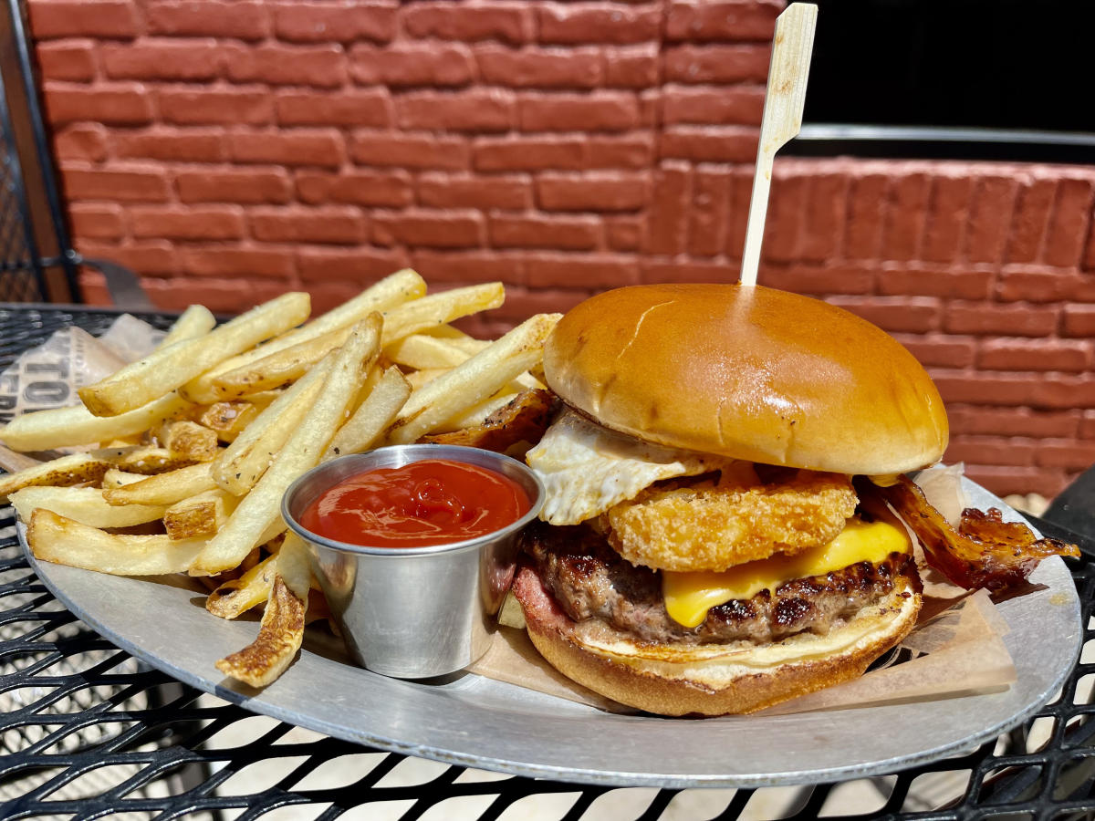 A breakfast burger is piled with hashbrowns and a fried egg at Bricktown Brewery