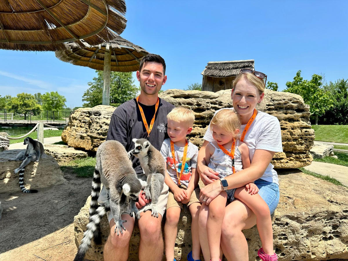 A mother and father feed lemurs with their two young daughters at Tanganyika Wildlife Park