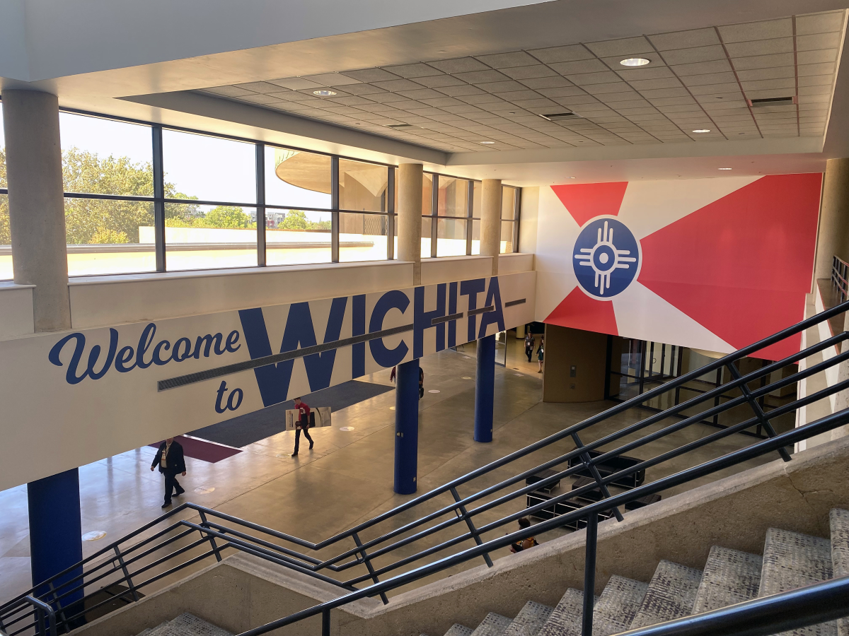 A Welcome to Wichita sign is hung over the stairs inside Century II Performing Arts and Convention Center