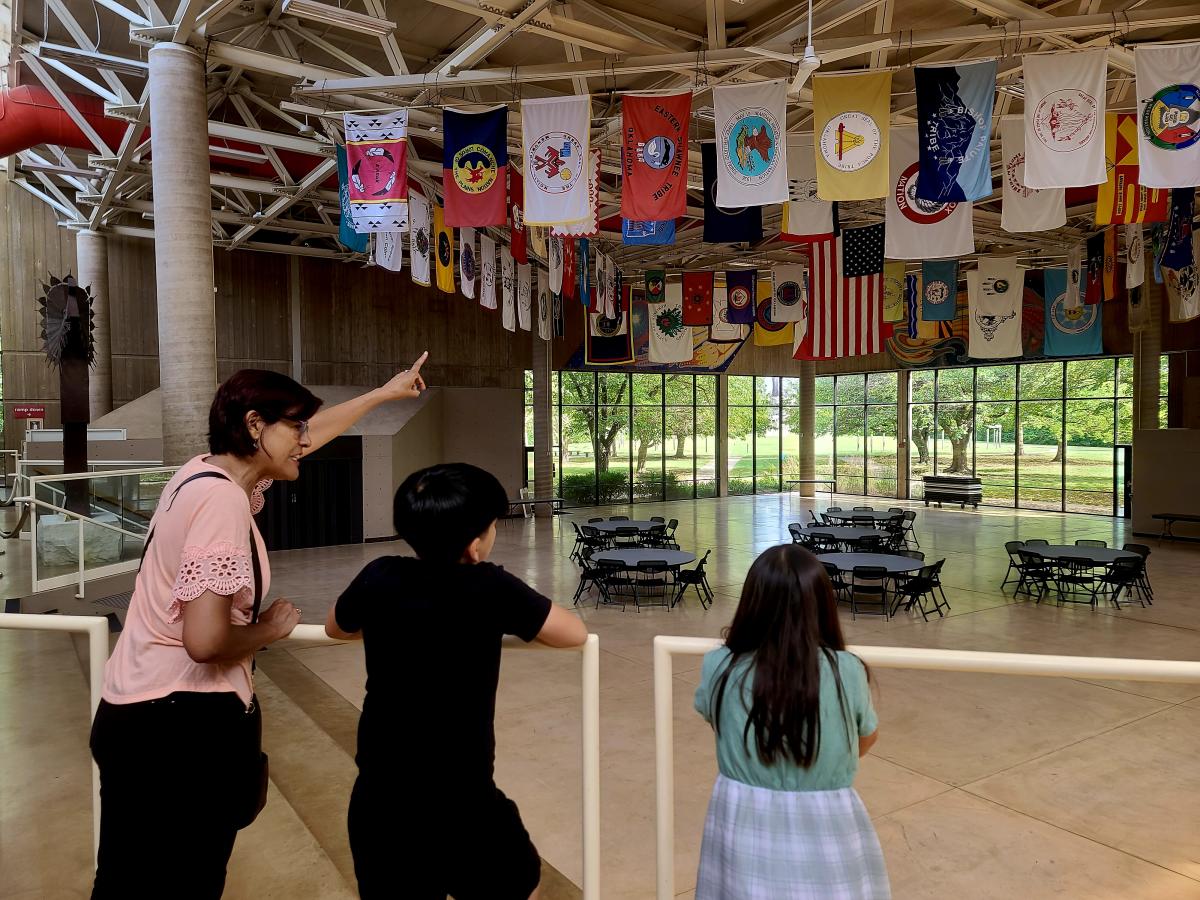A woman points to the flags on display at the Mid-American All-Indian Museum
