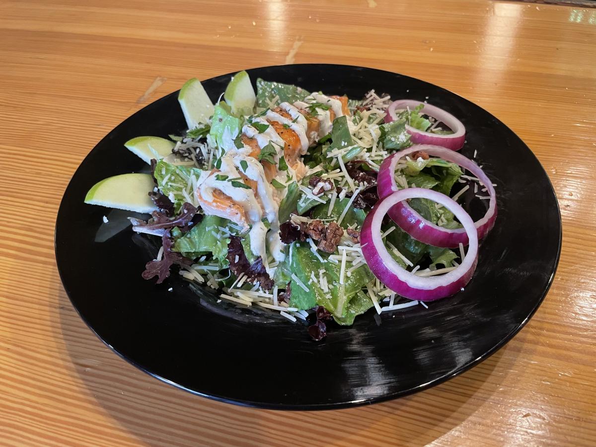 A salad topped with smoked salmon and onions is served at Monarch