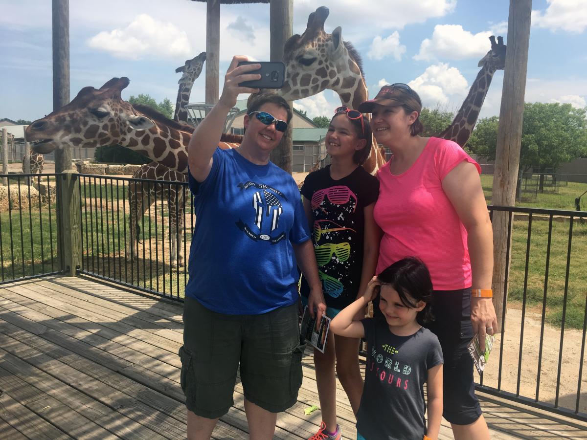 Two women take a selfie with a giraffe at Tanganyika Wildlife Park