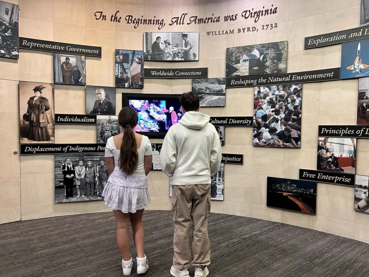 Two teens look at a museum exhibit about the early history of America