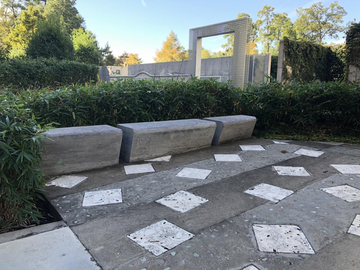 Concrete seating surrounded by fauna at The Koi Garden