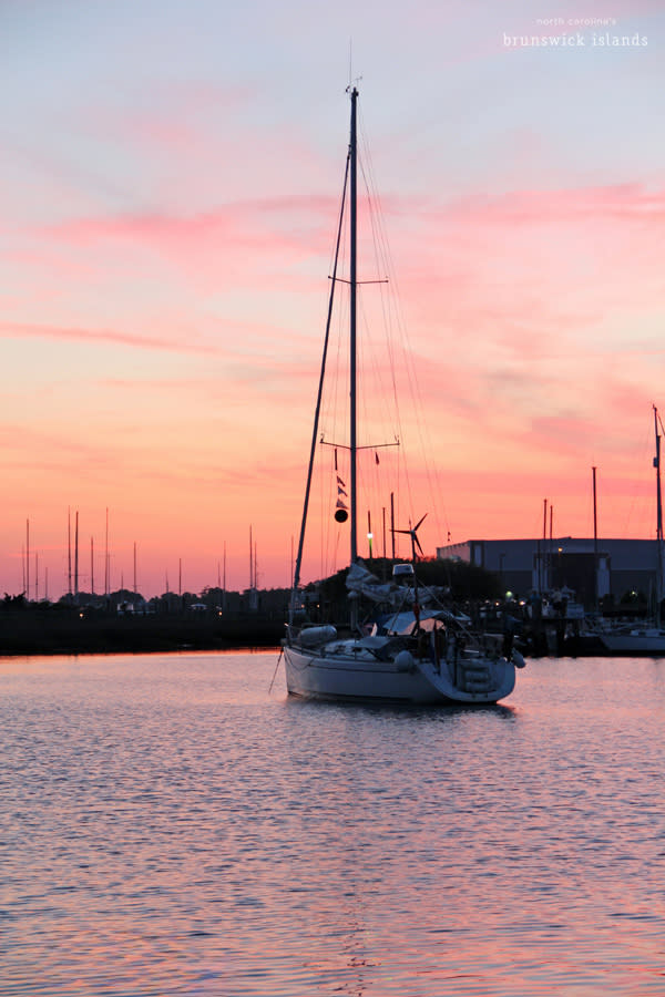 a sail boat in the Southport Yacht Basin at sunset
