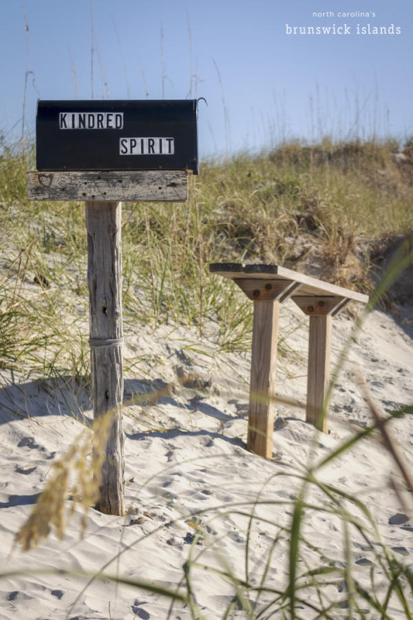 a mailbox labeled Kindred Spirit with a nearby bench in the dunes on Bird Island, NC