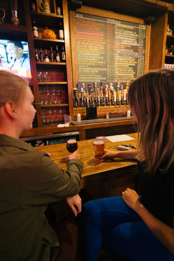 people have drinks at the bar at independent ale house in rapid city, sd