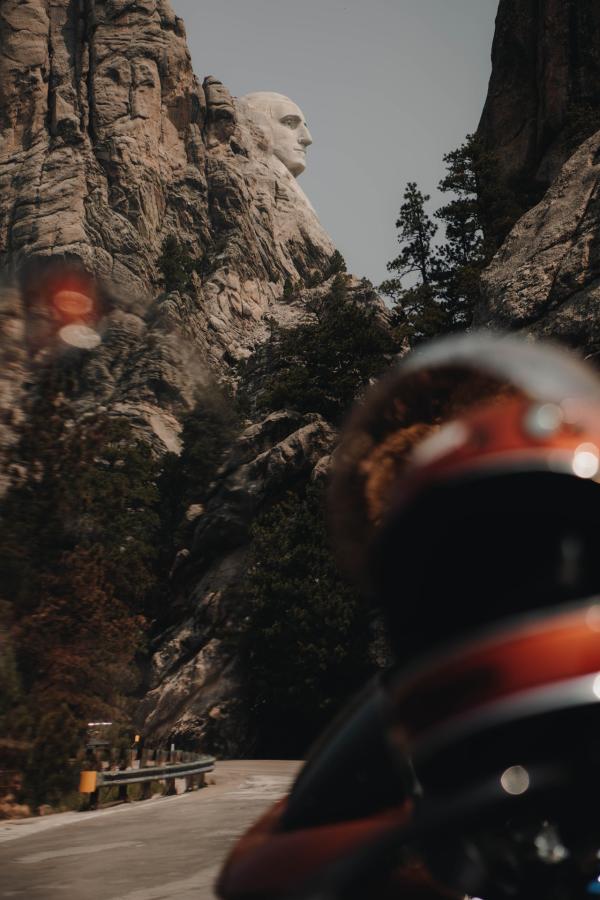 motorcycles parked with view of george washington on mount rushmore in the background