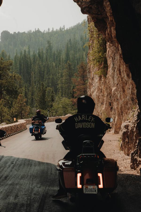 bikers driving through hood tunnel on their way to needles highway in custer state park