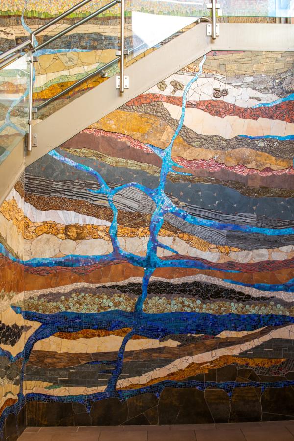 Strata Mosaic in Stairwell at Waterway Square in The Woodlands, Texas. Depicts a cross-section of the earth, starting in the atmosphere and working its way down to the core of the earth, including layers of grass, dirt, various types of rock and fossils, and natural underground water systems.