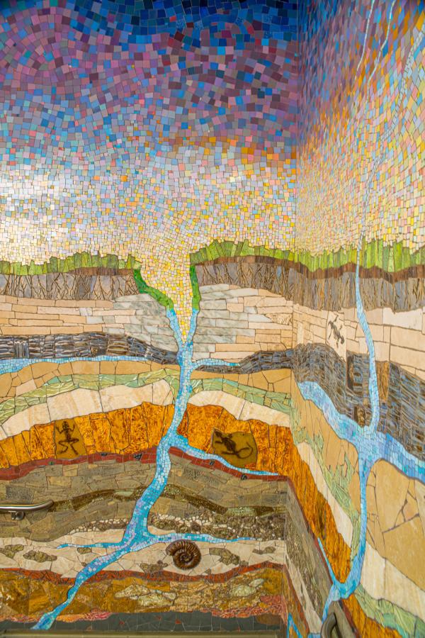 Strata Mosaic in Stairwell at Waterway Square in The Woodlands, Texas. Depicts a cross-section of the earth, starting in the atmosphere and working its way down to the core of the earth, including layers of grass, dirt, various types of rock and fossils, and natural underground water systems.