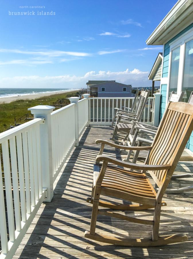 a wooden rocking chair on an outdoor deck of an oceanfront vacation rental home