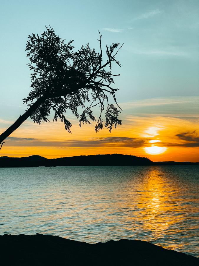 A glowing orange sunset over Lake Superior at Sunset Point on Presque Isle in Marquette, MI