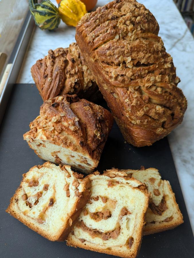 A sweet bread featuring apple pieces and cinnamon swirls in the middle is pictured at Sarkozy Bakery.