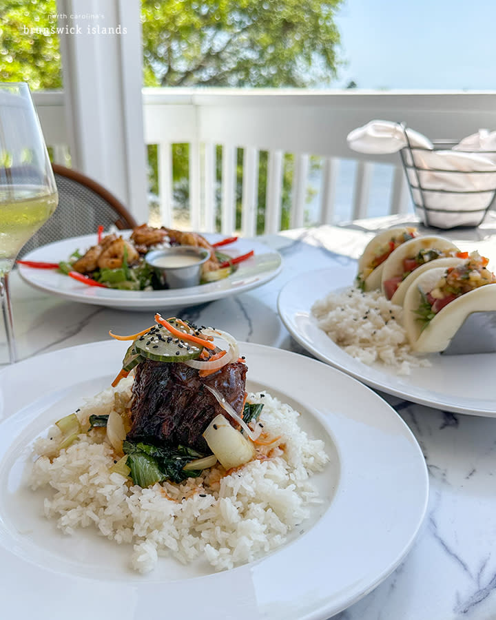 plates of steak, shrimp, and bite sized boa bun tacos at Oak and Palm Waterfront Dining in Sunset Beach