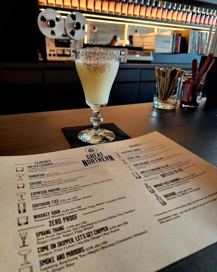 The drink shown has sprinkles and is cream color, shown with drink menu.