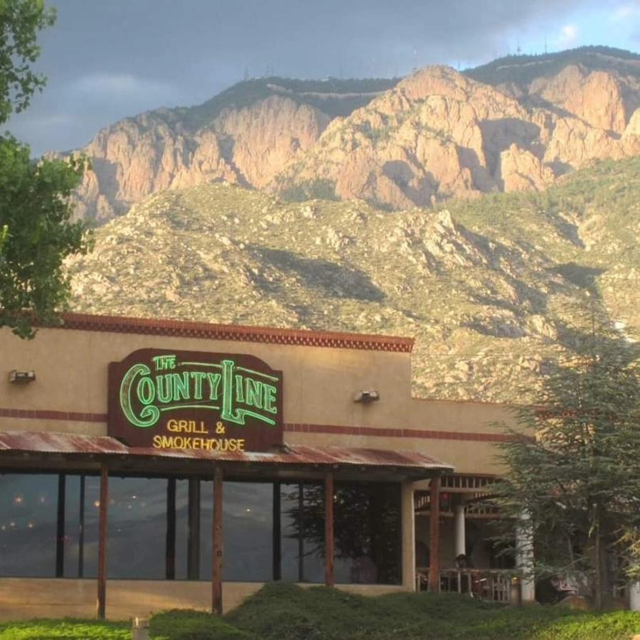The exterior of The County Line of Albuquerque. In the background are the Sandia Mountains.