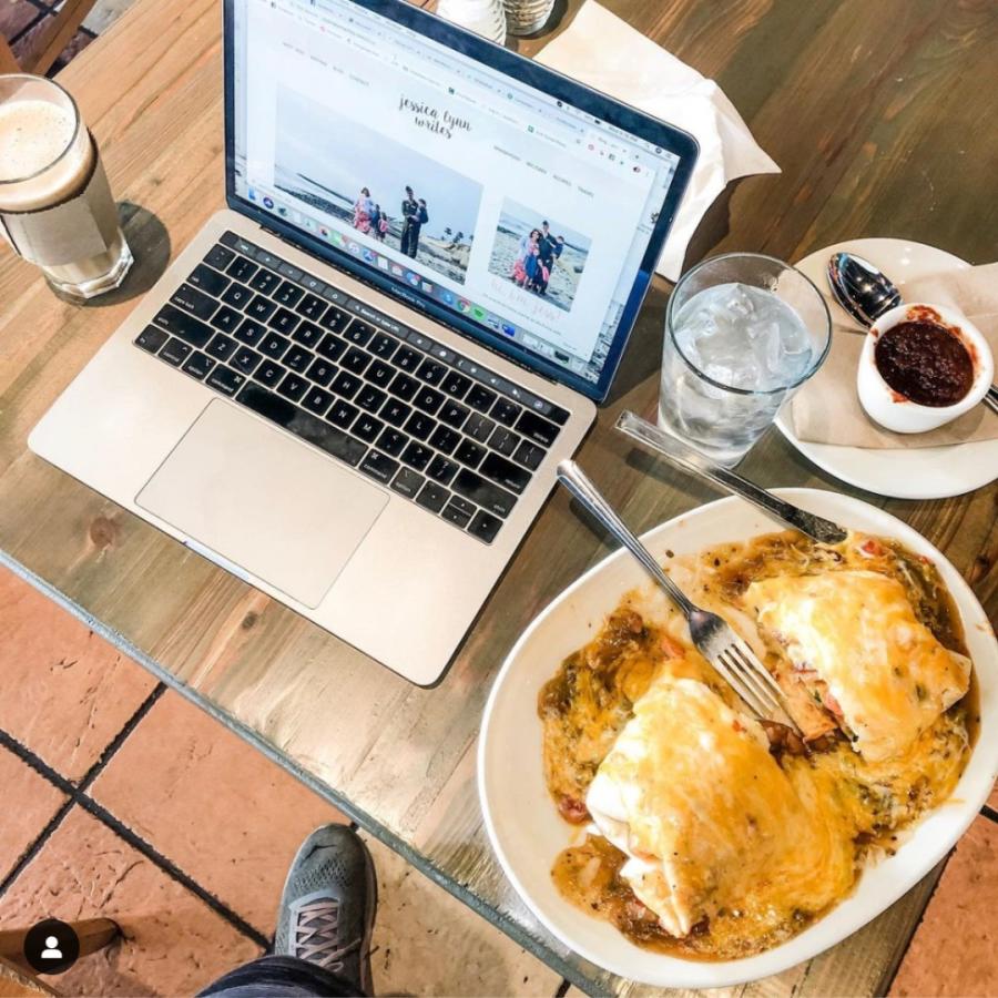A laptop sits open with food and drink from Flying Star next to it