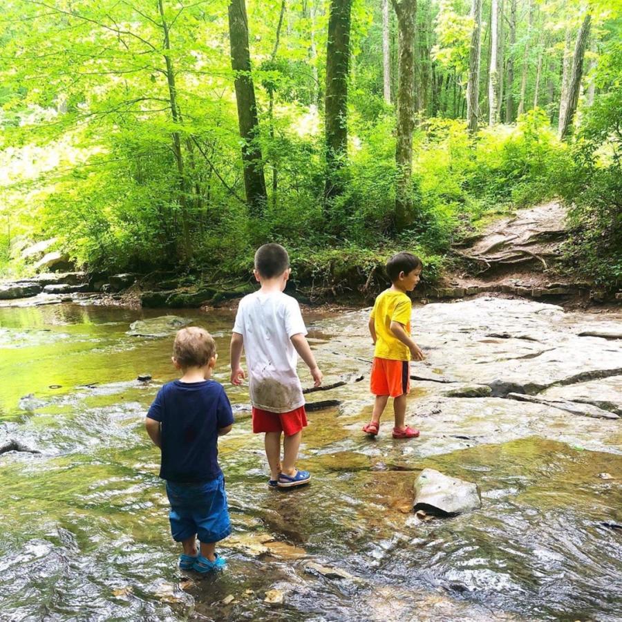 three boys in a creek