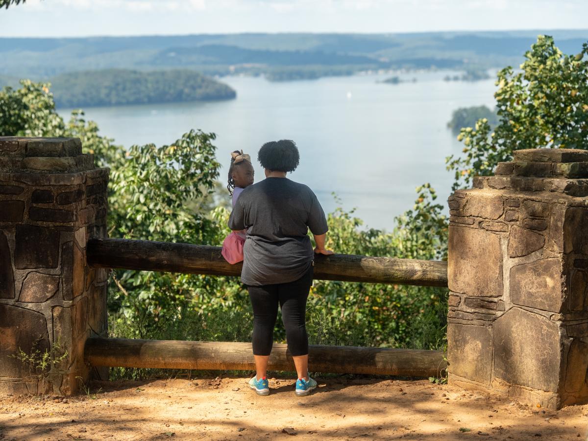Mother holding her child looking at the lake on the Bobo Accessible Trail.