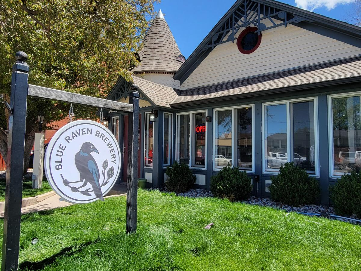Exterior view of Blue Raven Brewery with its distinctive sign and charming Victorian architecture in Cheyenne.