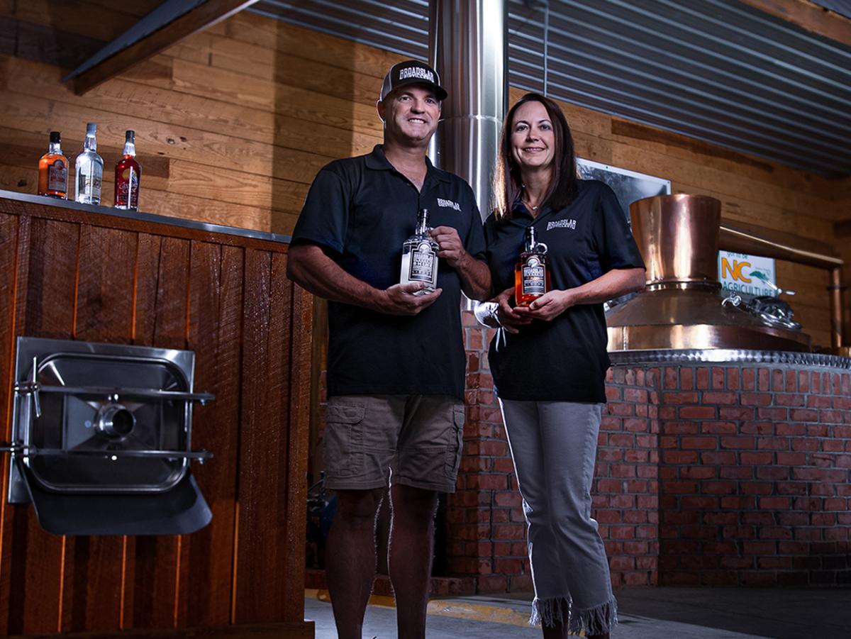 Jeremy & Shelly Norris of Broadslab Distillery Pose in front of Still