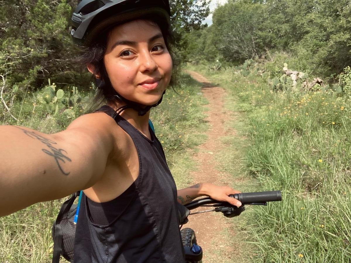 Young woman takes a selfie while mountain biking in San Marcos, Texas
