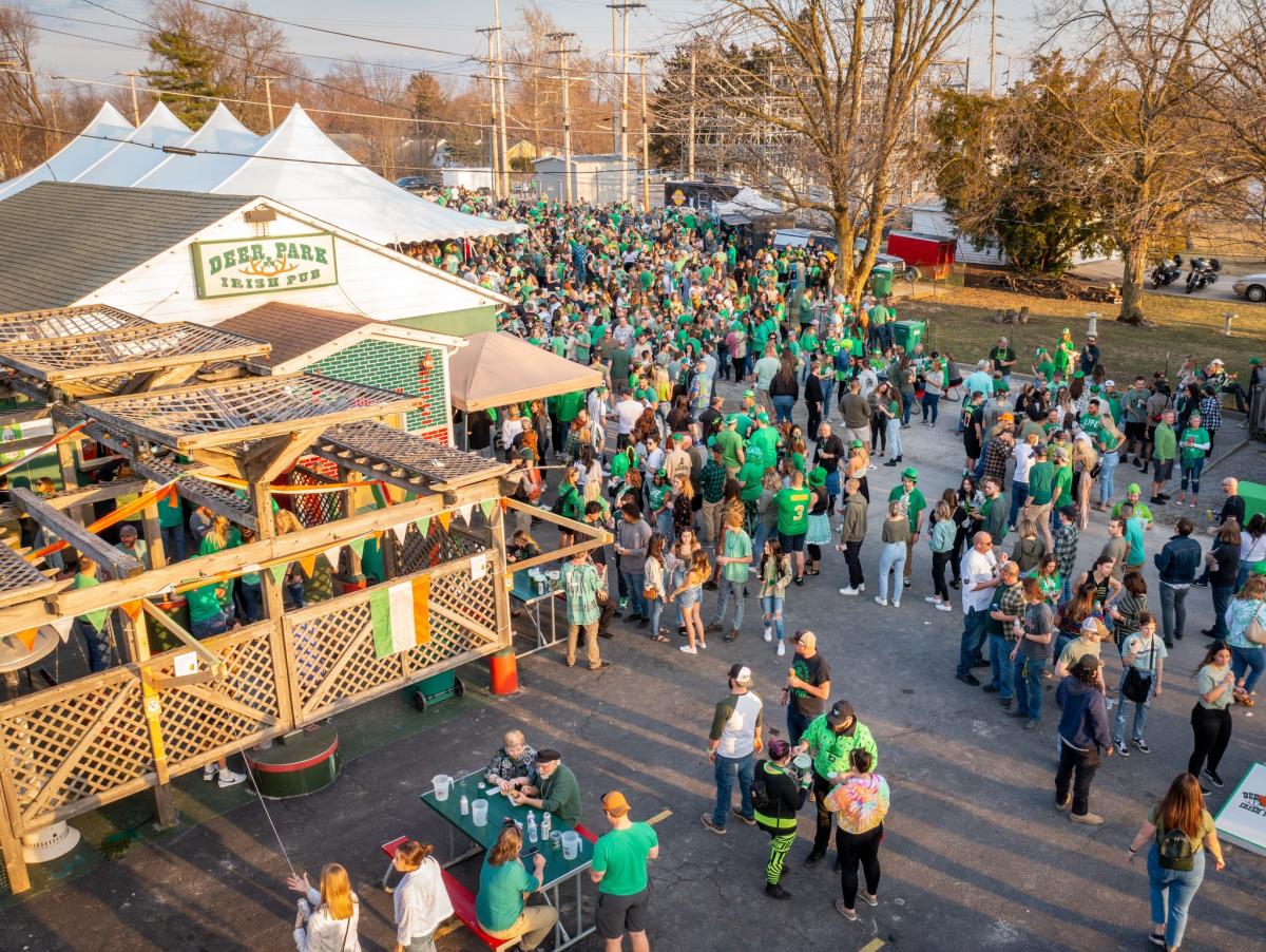 Outdoor St Patrick's Day celebration at Deer Park Irish Pub showing a crowd of people wearing green clothing