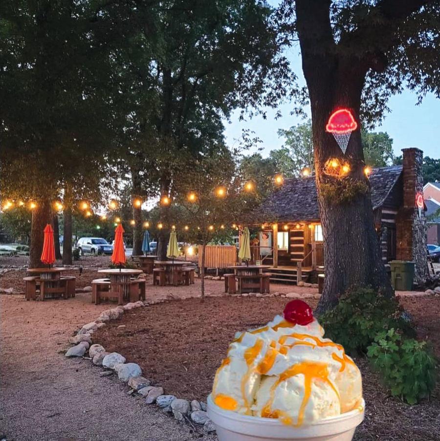 An ice cream sundae in the foreground with Pop's Cabin Creamery of Mauldin in the background.