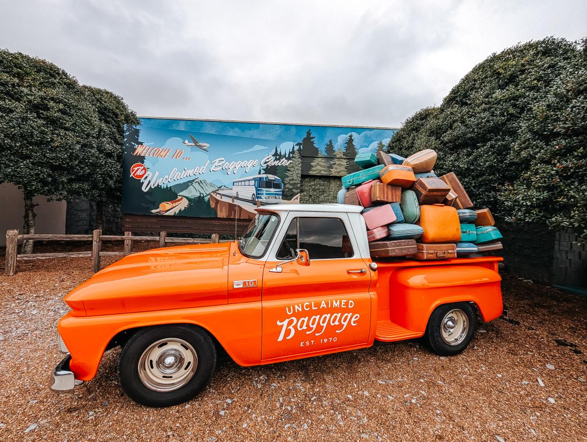 Vintage truck stacked with luggage at Unclaimed Baggage Center.