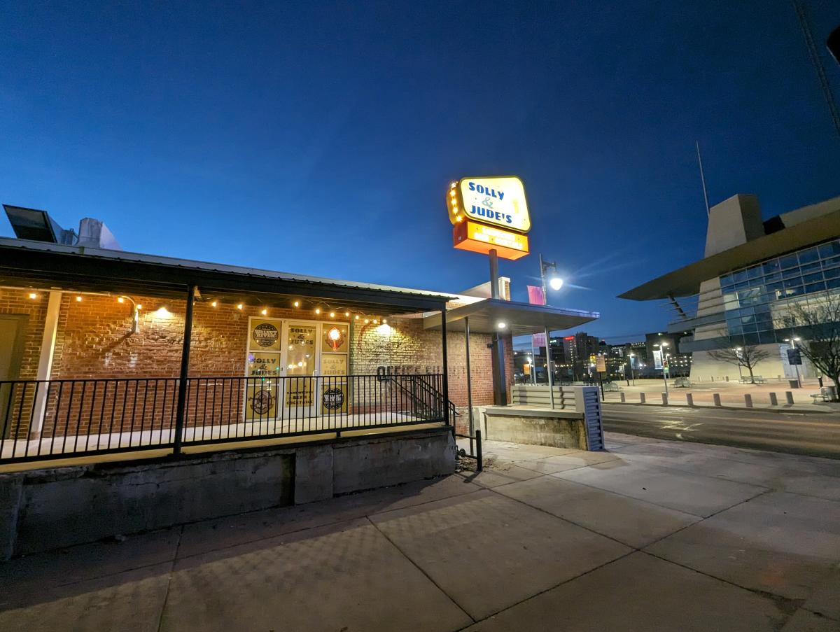 The exterior of Solly & Jude's features a lit sign across from INTRUST Bank Arena