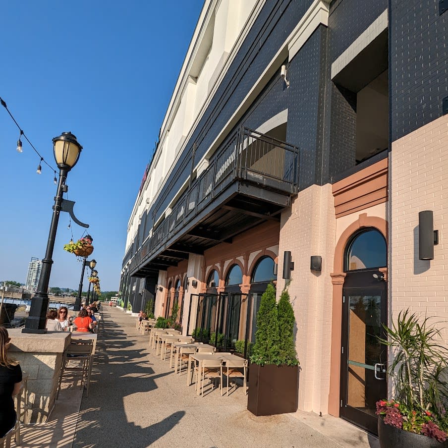 Images shows the outside of Amador facing the river with outdoor table and chairs.