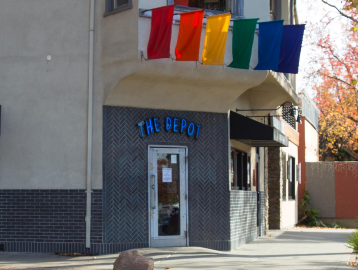 A building adorned with rainbow flags and a sign for The Depot