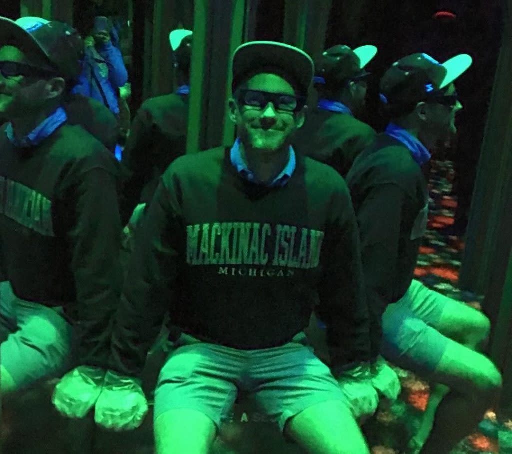 Multiple reflecting images of a man sitting inside Mackinac Island's Maze of Mirrors