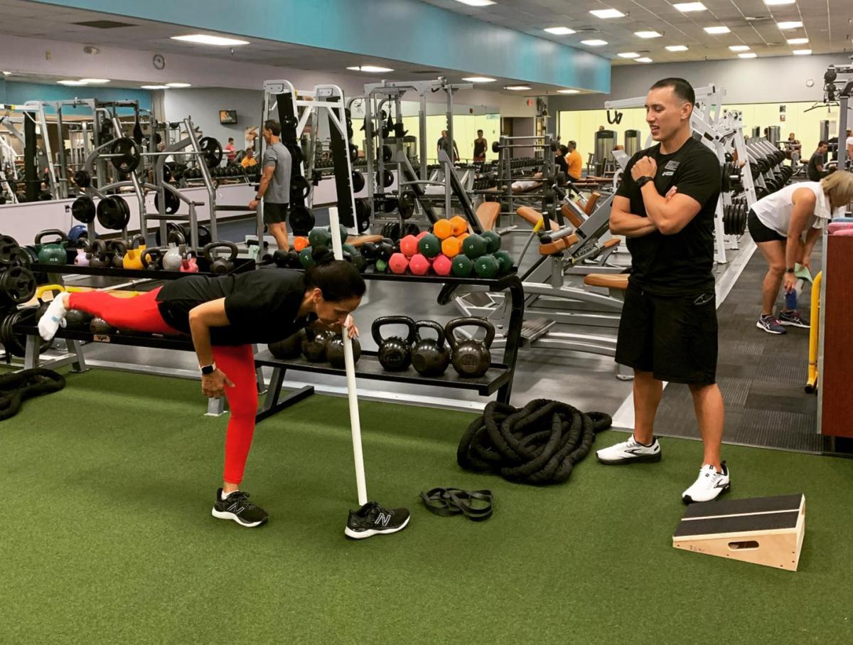 A woman does an exercise while a personal trainer looks on at Riverpoint Sports & Wellness.