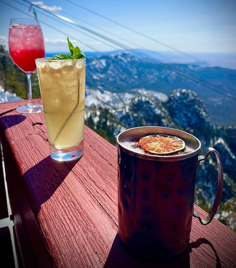 Three mocktails sit on a railing near TEN 3