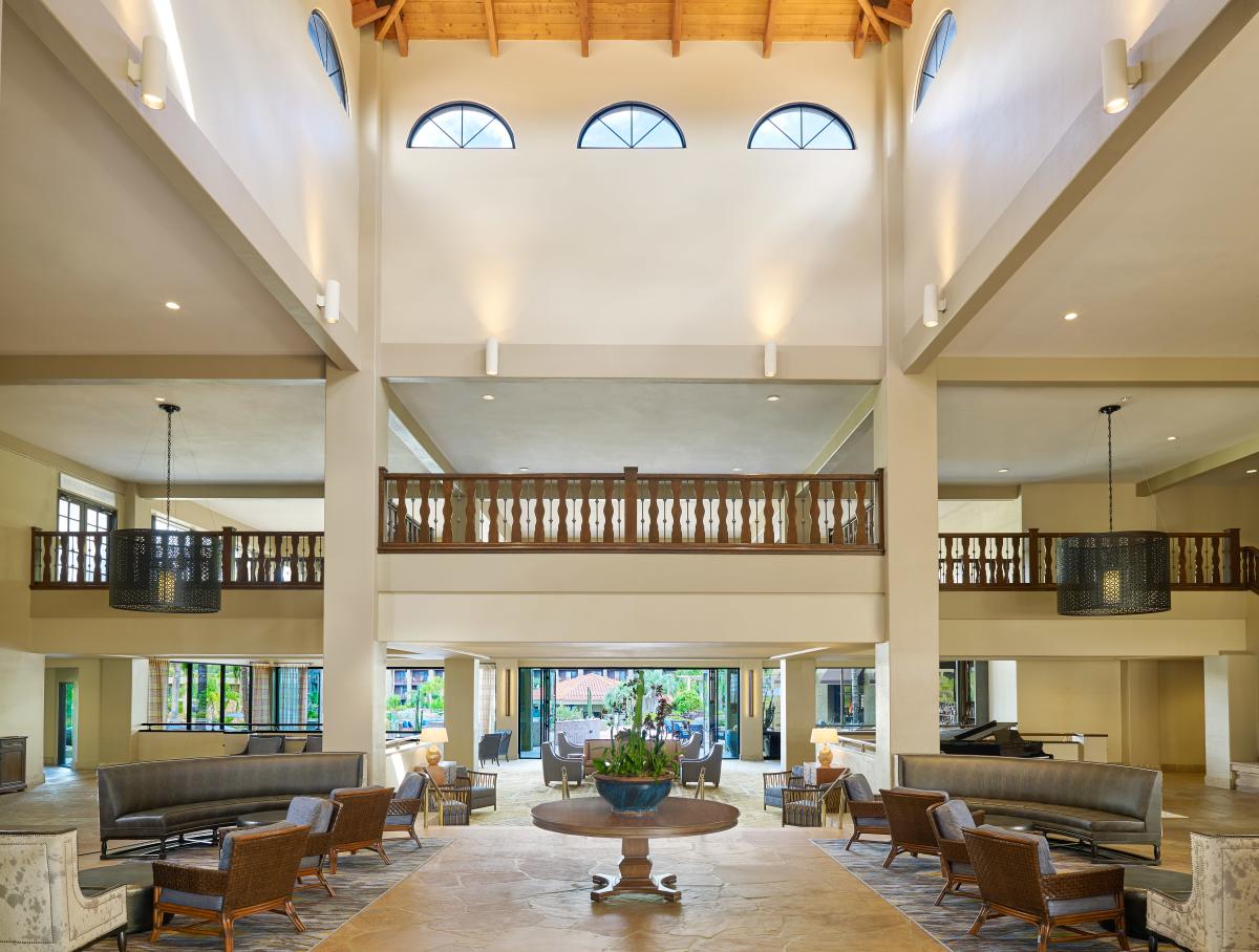 A large resort lobby with two floors, high ceilings, and a variety of seating
