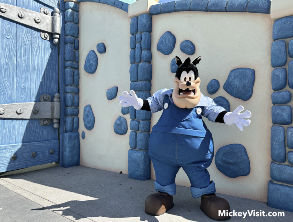 Image of Pete standing in front of a blue and white rock wall inside Mickey's Toontown.