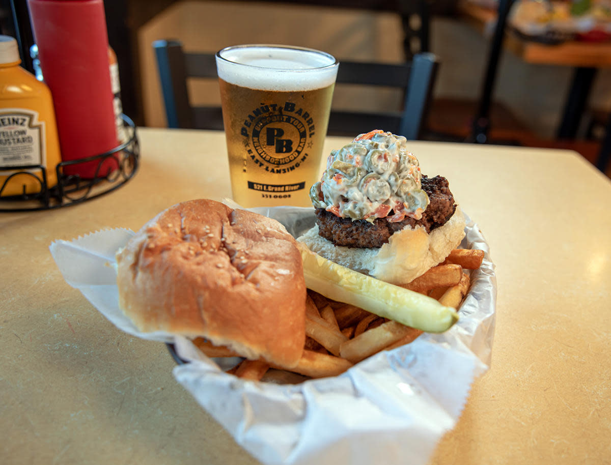 basket with a burger, pickle and french fries