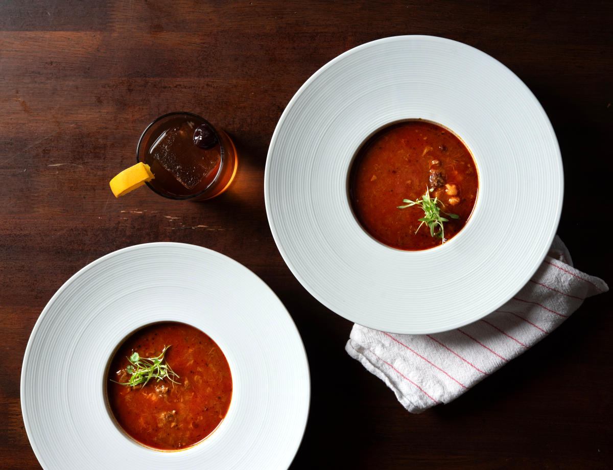 Bowl of red chile bison posole with hominy and tender bison in rich red broth.