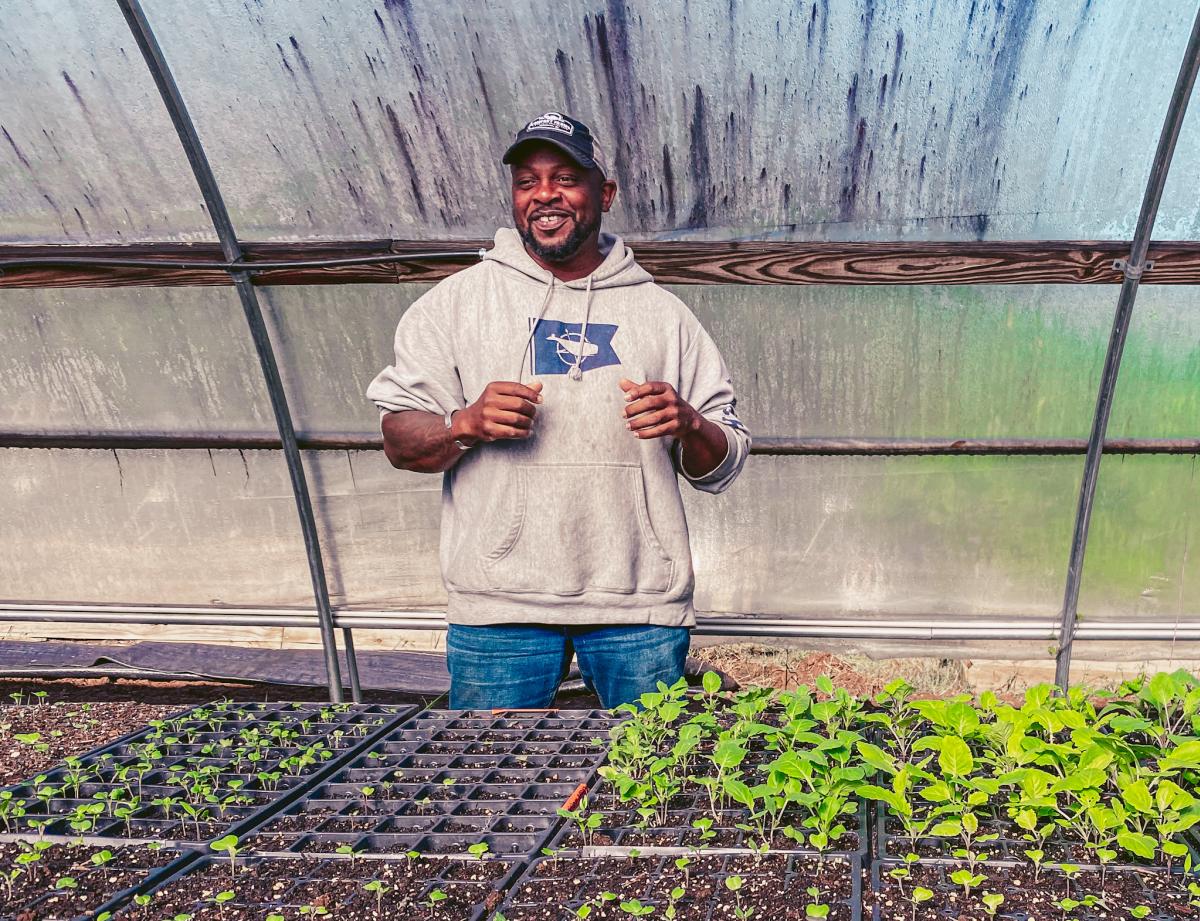 Jon inside greenhouse with plants at Comfort Farms.