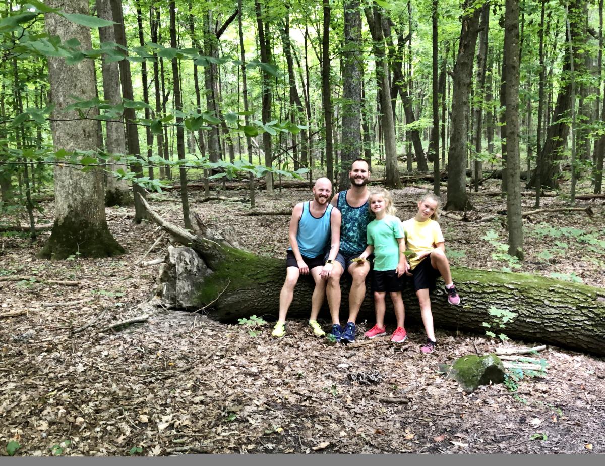 A family takes a break from hiking the Arboretum to post for a photo