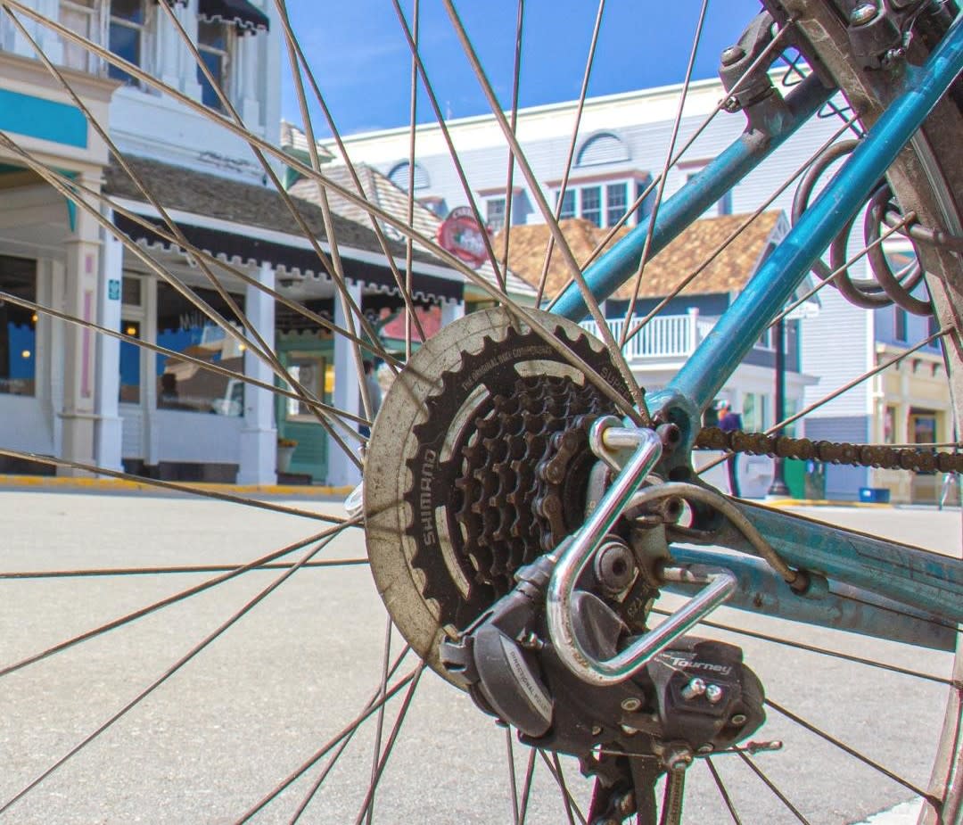 A Main Street Mackinac Island building seen through the spokes of a bicycle wheel