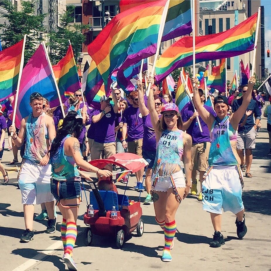 A group of young people holding rainbow flags in the Cincinnati Pride parade